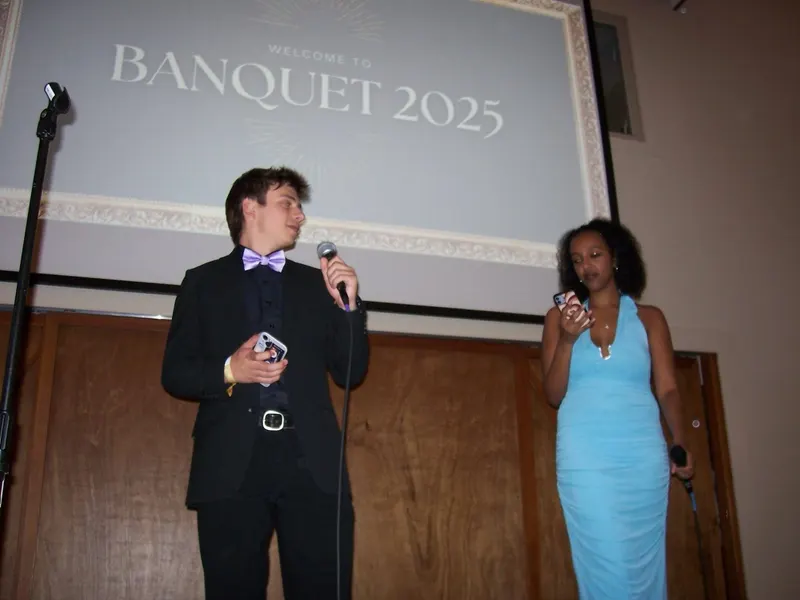 Two brothers hosting on stage under a Welcome to Banquet 2025 slide